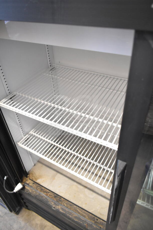 2024 True GDM-41SL-48-HC-LD commercial 2-door cooler, white interior shelves, black frame, clean and well-maintained.