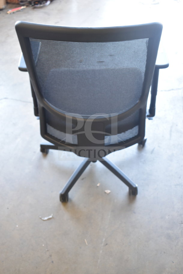 Mesh-back office chair with black frame and casters, in good condition. Part of a set of 12 chairs available at auction.