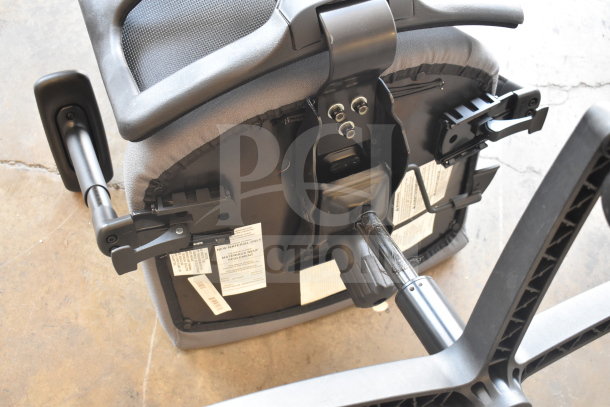 Set of 12 office chairs on casters, gray upholstery, adjustable armrests, labels indicate new material compliance.