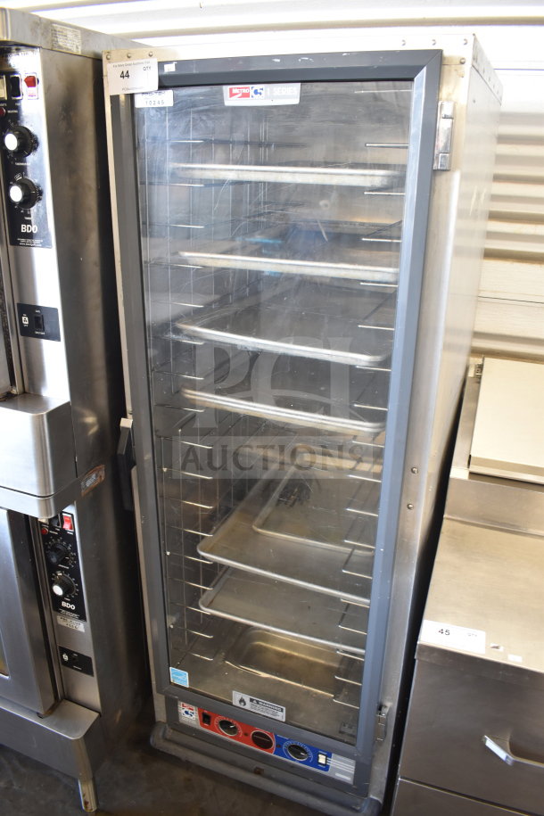 Metro 519-CFC-4 heated holding cabinet on casters, stainless steel, clear door, adjustable shelves, controls visible.