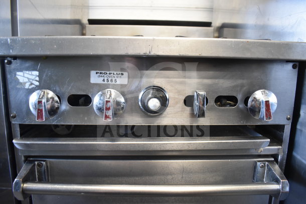 Commercial gas-powered 4 burner range with oven, stainless steel, features Pro-Plus label and dial controls, used condition.