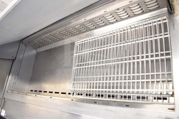 Avantco 178SSPT60MHC commercial sandwich salad prep table interior view with metal grates, showing clean stainless steel surface.