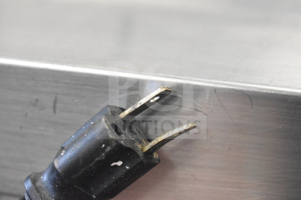 Avantco 178SSPT60MHC power plug, slightly worn, 115 volts, against stainless steel surface of prep table.