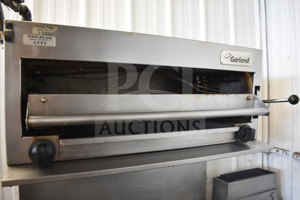 Garland SunFire commercial gas range with 6 burners, salamander cheese melter, oven, and over shelf. Visible label: Pro-Plus 4560.