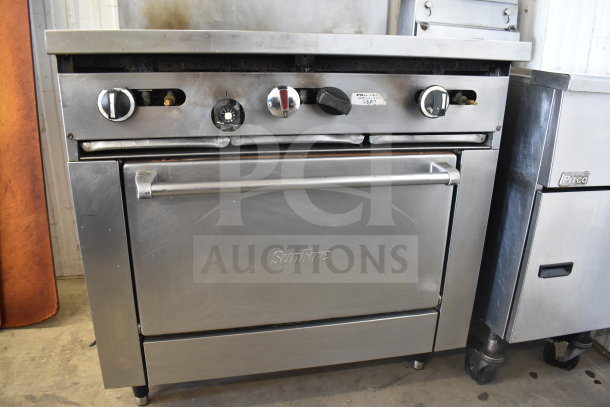 Garland SunFire commercial gas range, 6 burners, salamander cheese melter, oven, over shelf. Stainless steel, used condition.