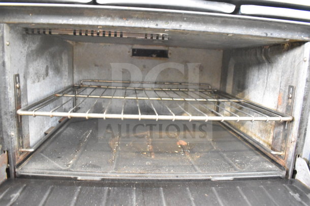 Garland SunFire commercial gas range oven interior; features include six burners, salamander cheese melter, and upper shelf.