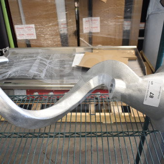 Brand new commercial dough hook attachment with minor scratches and dents, shown on a display shelf with auction label.
