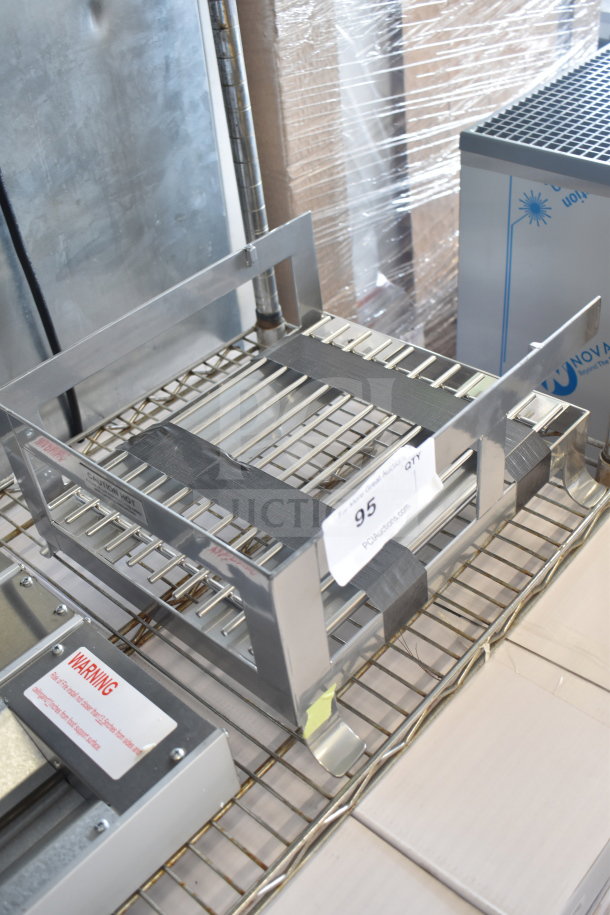 "New scratch and dent unit, stainless steel rack, tags labeled caution and auction number 95 visible, on metal shelf."