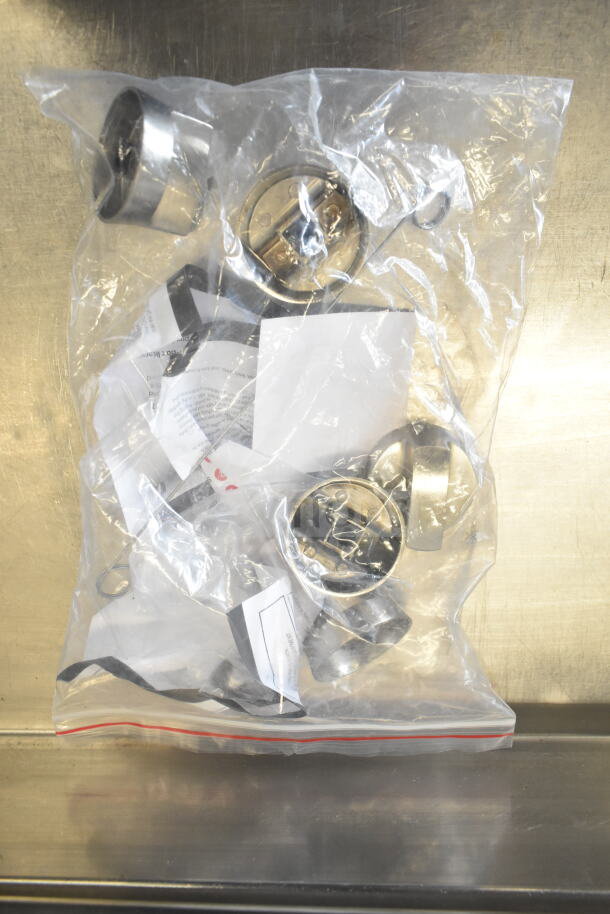 A sealed plastic bag with assorted metal components and paper tags inside, possibly for assembly or maintenance.