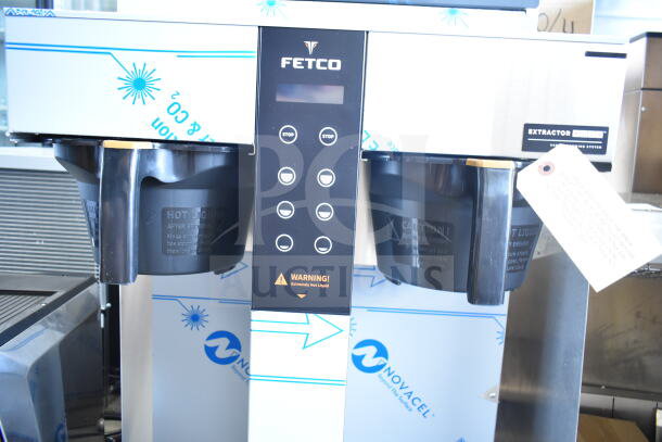 Brand new 2025 Fetco CBS-1252 Plus Series Twin Automatic Digital Coffee Brewer, with plastic brew basket, dual stop buttons, and caution label.