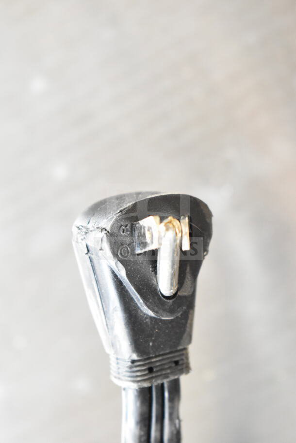 Close-up of a black electrical plug with visible scratches and minor damage on the surface.