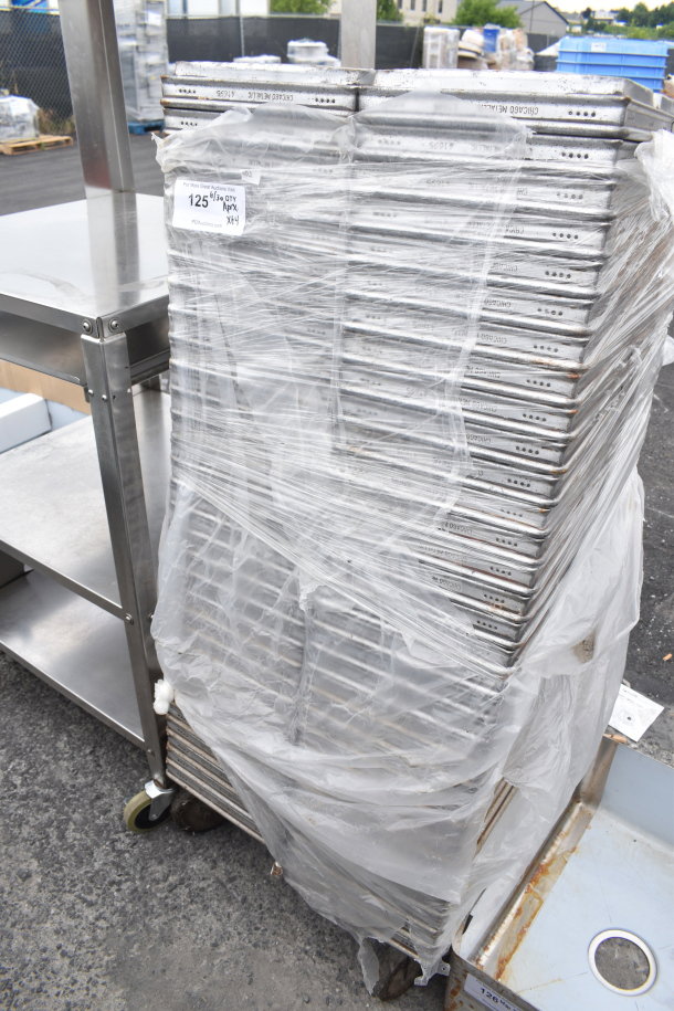 Stack of 64 metal baking pans wrapped in plastic, showing "Chicago Metallic" branding, indicating industrial quality.