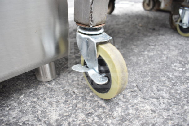 Cart with over and 2 under shelves on commercial casters; detailed image of caster wheel, showcasing sturdy design.