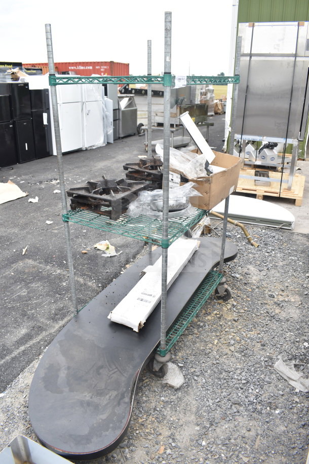 Green finish 3-tier wire shelving unit on commercial casters, includes contents. Buyer must dismantle; freight needed.