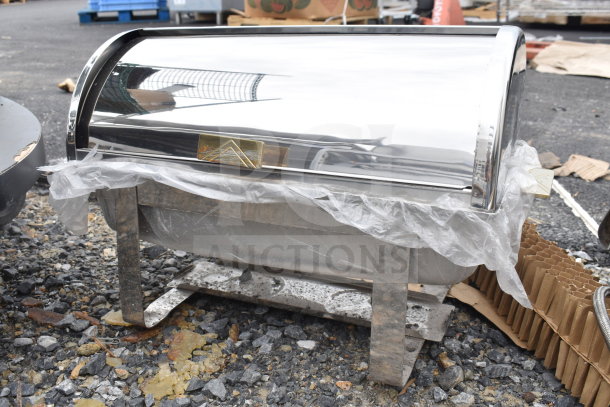Stainless steel roll top chafer, shiny finish, visible brand plaque, good condition with protective wrap, sturdy legs.