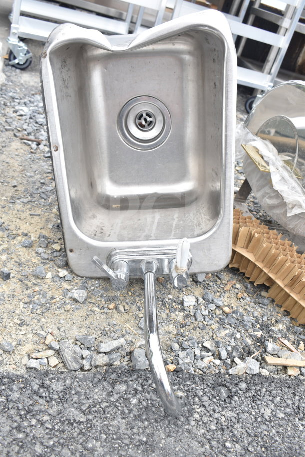Stainless steel single bay drop-in sink with attached faucet and handles, showing wear, no visible brand markings.