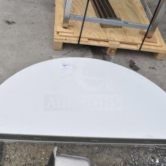 Brand new scratch and dent round bi-fold folding table, partially folded, shows minor surface imperfections, auction tag visible.