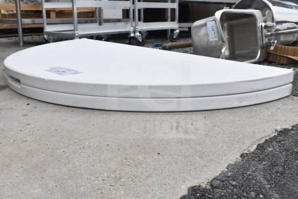 Brand new white round bi-fold folding table with minor scratches and dents. Tags indicate as new condition.