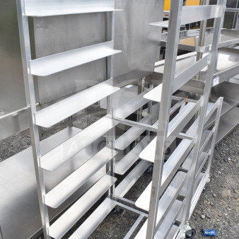 Brand new metal pan transport rack with scratch and dent, featuring commercial casters, multiple shelves, and sturdy frame.