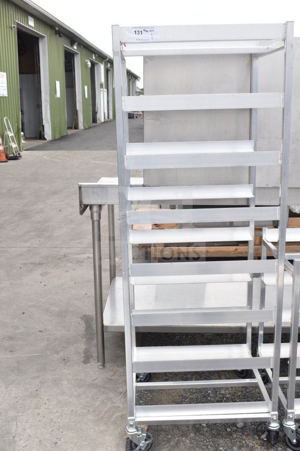 Brand new metal pan transport rack with scratches, on commercial casters. Features label: "131 19 QTY".