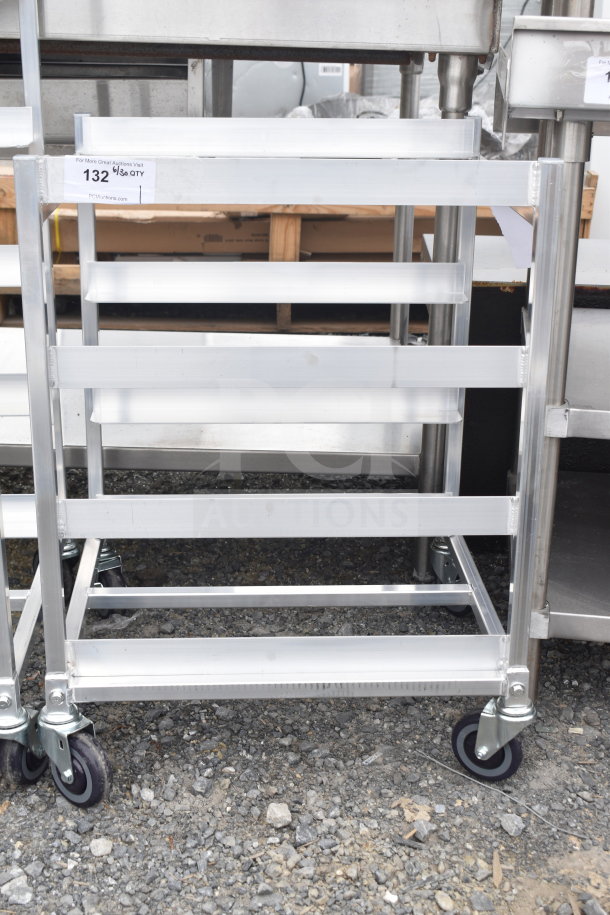 Brand new metal pan transport rack with minor scratches, on commercial casters. Suitable for industrial kitchens. Marked as "132 1/8 QTY."