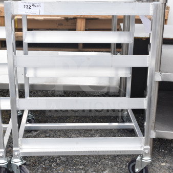 Brand new metal pan transport rack with minor scratches, on commercial casters. Suitable for industrial kitchens. Marked as "132 1/8 QTY."