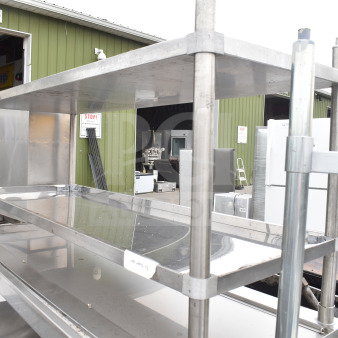 Stainless steel table with two under shelves, new with minor scratches and dents, suitable for storage or kitchen use.