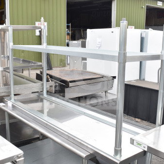 Brand new scratch and dent stainless steel table with under shelf, featuring sturdy construction and visible minor imperfections.