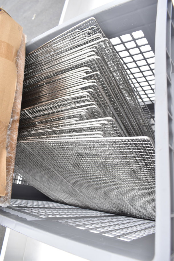 Stainless steel mesh tray racks, brand new with minor scratches and dents, stacked in a gray bin. Total of 50 trays.