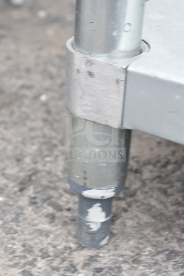 Brushed metal table leg with visible scratches on a Regency 600TB3072G table, shown on concrete surface.