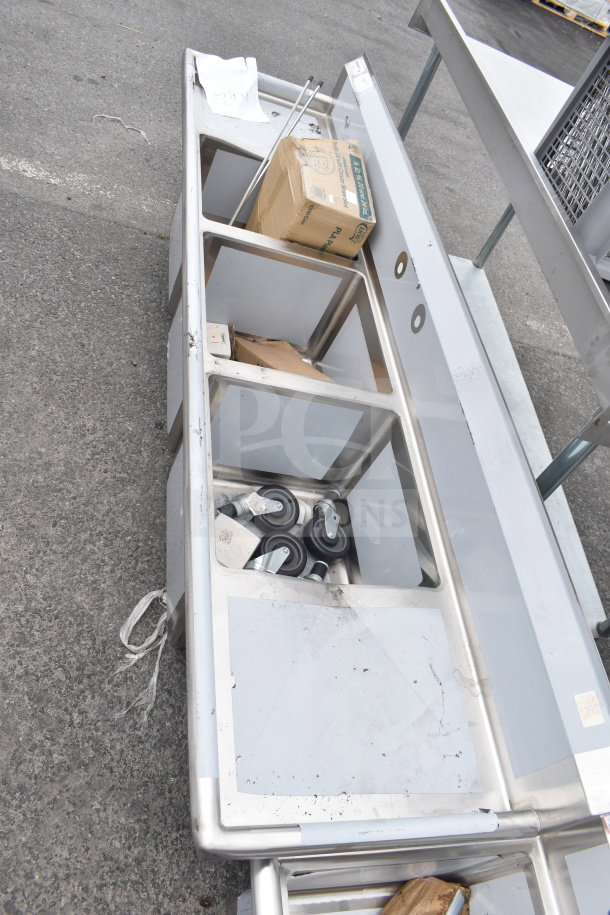 Brand new Regency 600S31818218 3 bay sink with dual drain boards. Slight scratches and dents visible. Includes boxes and casters.