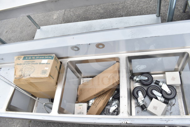 BRAND NEW SCRATCH AND DENT Regency 600S31818218 3 bay sink with dual drain boards, visible minor wear, includes casters.