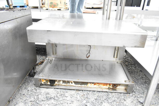 Commercial cheese melter, stainless steel, used condition with visible wear and rust, missing operational parts.