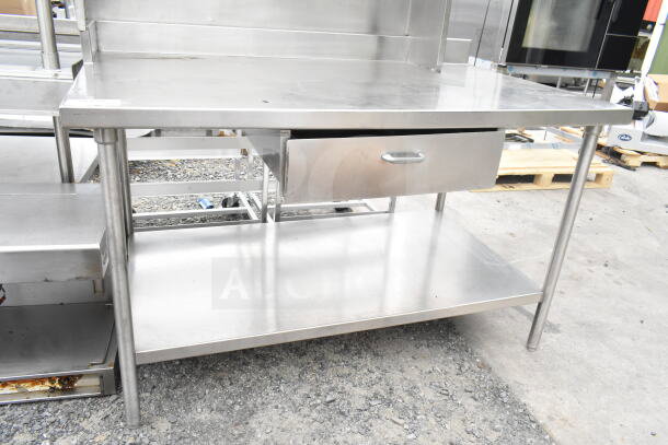 Stainless steel table with over shelf, drawer, and under shelf. Sturdy construction, ideal for kitchen or workspace use.