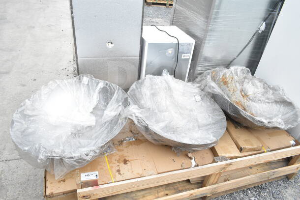 Three carbon steel Cantonese woks wrapped in plastic on a wooden pallet, labeled as Scratch and Dent items, brand new condition.