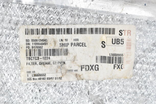 A shipping label on bubble wrap showing various codes and text, including "FILTER, GREASE, C3 OVEN" and other details.