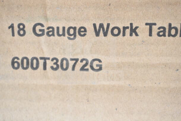 Close-up of a box with "18 Gauge Work Table" and model "600T3072G" printed, indicating contents inside.