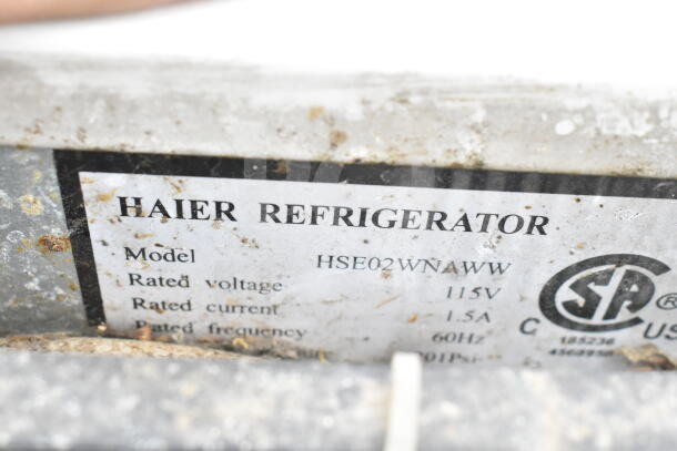 Label on Haier Refrigerator, Model HSE02WNAWW, 115V, 1.5A, 60Hz. Visible wear marks and branding details.