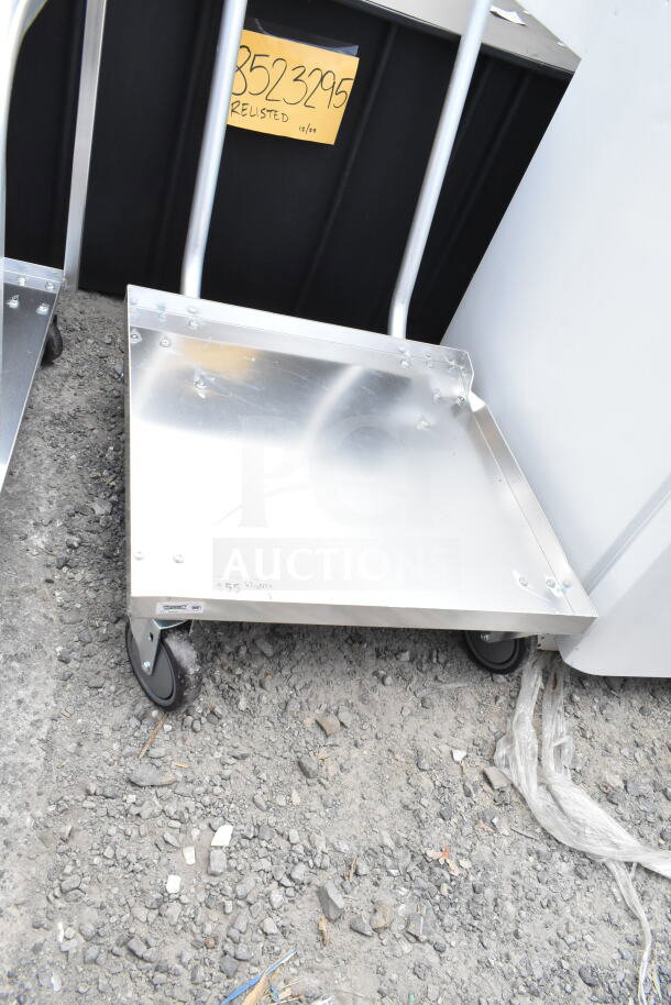 Alt text: Brand new Regency aluminum dolly, 23 3/16" x 23 3/16", scratch and dent condition, with handle and caster wheels.