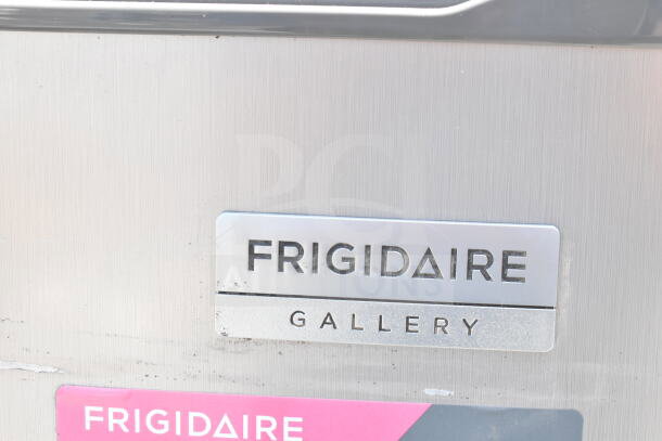 Frigidaire Gallery label on stainless steel surface, indicating a featured freezer included in the auction lot.