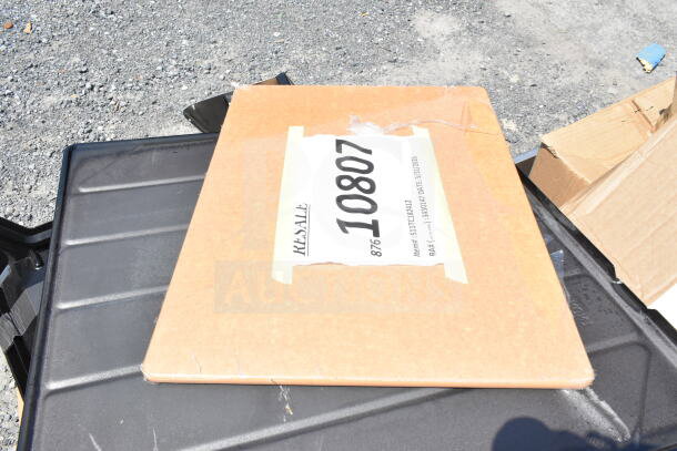 A cardboard box labeled "RESALE 10807" lies on a black surface, indicating resale or auction status.