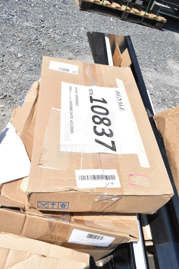 Cardboard boxes labeled "10837" on gravel, containing scratch and dent items like Speed Rail, canopy tent, serving trays.