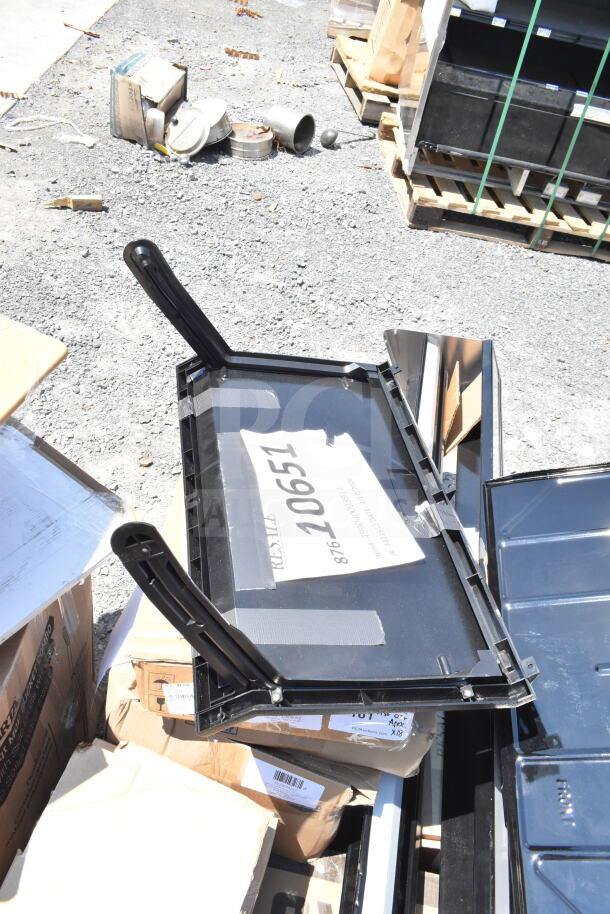 Stack of items including a folded canopy tent, speed rail, and serving trays, scratch and dent, with labels visible.