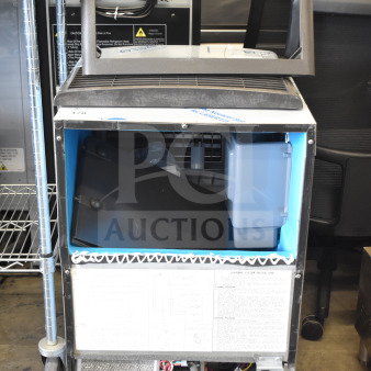 Brand new Manitowoc UDP0080A-161 ice machine, air cooled, 31 lb. bin, 110 lb. capacity, visible internal components, tags attached.