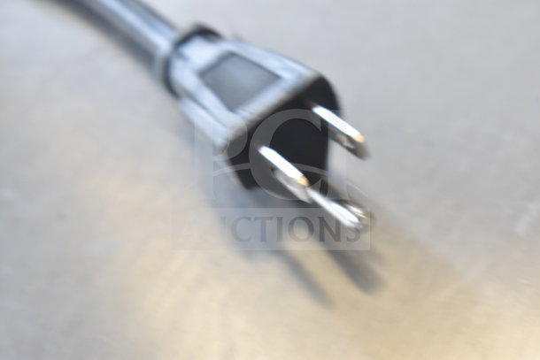 Blurry close-up of a standard power plug for IDW G-4.35SS-N234B Mini Cooler Merchandiser, 110-120 Volts.