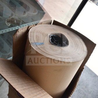 Large roll of brown paper, brand new, slight scratch and dent, in original cardboard packaging.