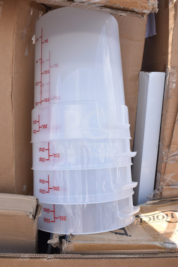 Stack of translucent plastic containers with red volume markings up to 22 liters. Seen amid cardboard packaging.
