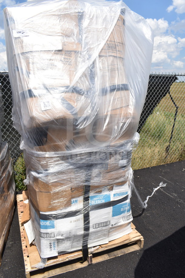 Pallet of boxed items wrapped in plastic, labeled "Monogram Bleach." Includes scratch and dent chairs.