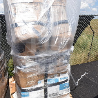 Pallet of boxed items wrapped in plastic, labeled "Monogram Bleach." Includes scratch and dent chairs.