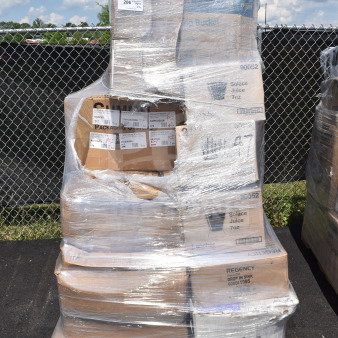 Plastic-wrapped pallet with various items including boxes labeled for pots, plates, juice cups, and forks. Scratch and dent condition.